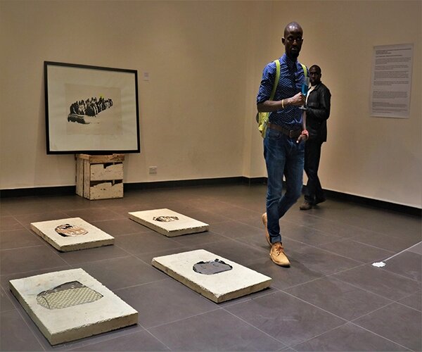 An Art enthusiast looks at works by Longinos Nagila at exhibition by the Artspace, (at the Simba Corp Aspire, Nairobi)
